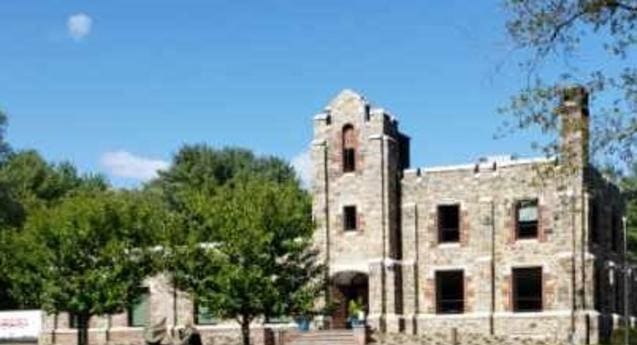 A large stone building with trees in front of it.